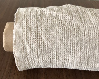 Könnte beinhalten: Eine Rolle beige Waffelstoff. Der Stoff ist weich und strukturiert und eignet sich perfekt für eine Vielzahl von Bastelprojekten.