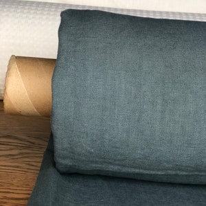 May include: A roll of dark teal linen fabric. The fabric has a textured weave and is folded in half.