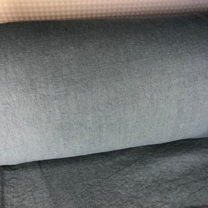 May include: Close-up of three fabric swatches. The top swatch is a light beige with a subtle pattern. The middle swatch is a dark gray. The bottom swatch is a slightly lighter gray.