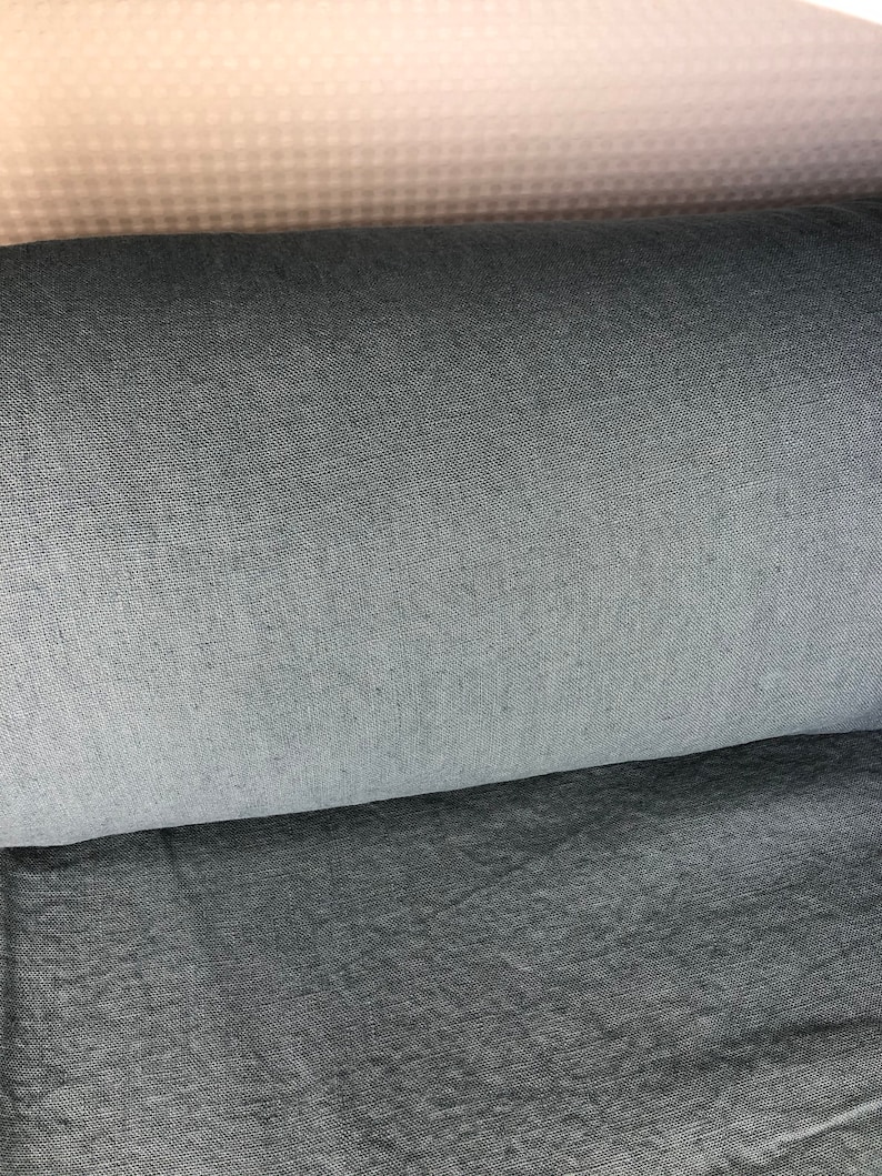 May include: Close-up of three fabric swatches. The top swatch is a light beige with a subtle pattern. The middle swatch is a dark gray. The bottom swatch is a slightly lighter gray.