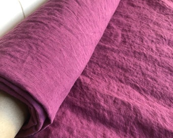May include: A roll of deep purple linen fabric. The fabric has a textured, slightly wrinkled appearance.