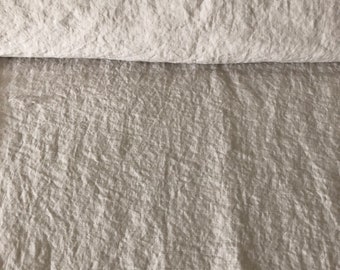 May include: A close-up of a roll of natural linen fabric with a textured, crinkled surface.