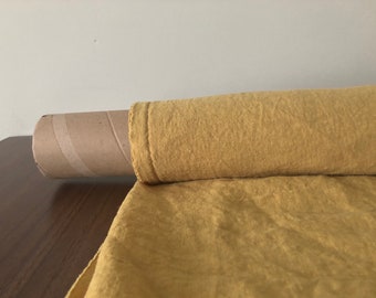 May include: A roll of yellow linen fabric on a cardboard tube. The fabric has a textured surface and is folded in half.