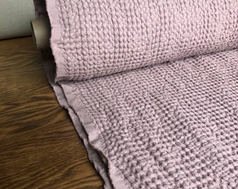 May include: A roll of soft, textured, light purple fabric. The fabric has a waffle-like texture and is perfect for making blankets, throws, or other home decor items.