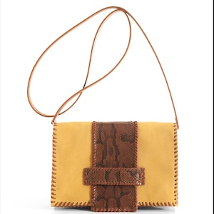 Puede incluir: Un bolso bandolera de ante amarillo con un panel de piel de serpiente marrón y un ribete cosido.