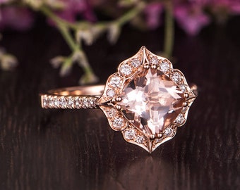 Könnte beinhalten: Ein Verlobungsring aus Roségold mit einem quadratischen Morganit-Mittelstück, das von einem Halo aus kleineren Diamanten umgeben ist. Der Ring hat ein zartes, floral inspiriertes Design.