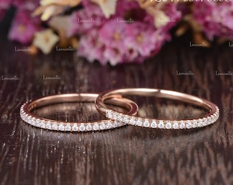 May include: Two rose gold wedding bands with a thin row of diamonds around the entire band.