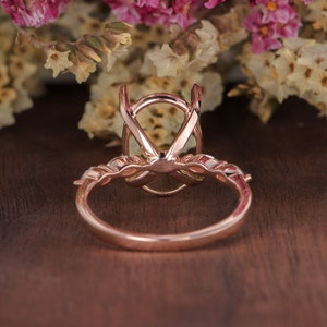 May include: Rose gold engagement ring setting with a delicate oval shaped center stone and a pave diamond band.