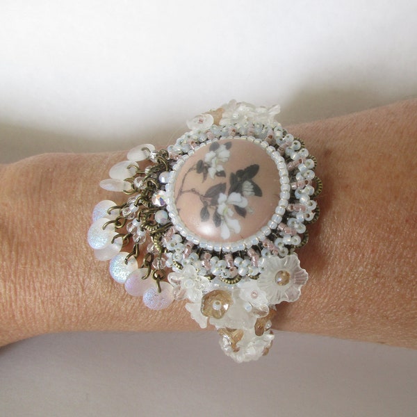 Bracelet japonisant, manchette rigide, avec un cabochon artisanal en porcelaine, des perles lentilles et des perles fleurs