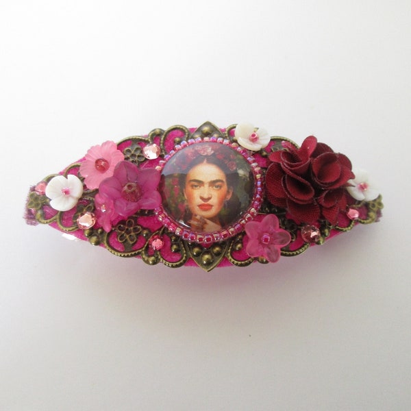 Barrette nuances bordeaux, avec un cabochon visage Frida, des perles fleurs, une fleur en tissu, et des strass swarovski