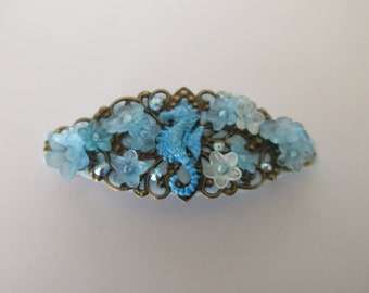 Barrette hippocampe, 8cm, bleu turquoise, avec des perles fleurs lucite, des breloques en métal teinté et des strass swarovski