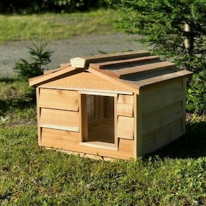May include: A wooden dog house with a cedar shingle roof. The house has a small window and a raised platform for the dog to enter.