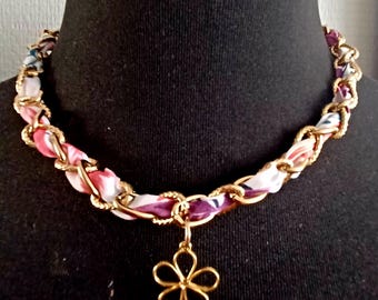 Necklace with a gold chain, a liberty cord and a chiseled flower charm