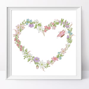 Puede incluir: Un marco blanco con una corona floral en forma de corazón en tonos de rosa, morado y azul. Una mariposa rosa vuela sobre la corona.