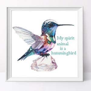 May include: A framed print featuring a colorful hummingbird illustration. The bird is depicted with blue, green, and pink hues, perched on a crystal-like structure. Text reads "My spirit animal is a hummingbird."