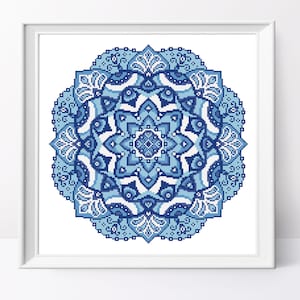 May include: A blue and white mandala pattern with intricate details. The mandala is circular and has a symmetrical design.