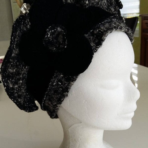 Béret, bonnet, chapeau femme en laine grise et blanche rehaussé d'une jolie fleur noire à  quatre pétales