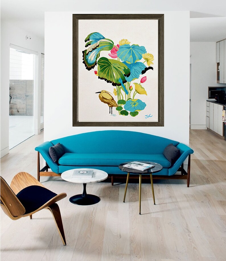 Print of my original water lilies painting featuring a nature scene with a golden wading bird and vibrant lotus plants against a white background. A long-beaked, golden-brown bird stands in ripples of water at the bottom left. Large, oversized lily pads in shades of bright green, teal, and turquoise dominate the center, detailed with delicate blue veins and scalloped dark edges. Soft pink and pale yellow lotus blossoms bloom on tall, slender stems. Signed "JeC" in script at the bottom right.