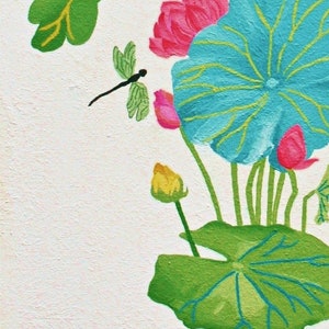 My painting of a blue and green lotus flower with pink and yellow buds. A dragonfly is flying above the flower.