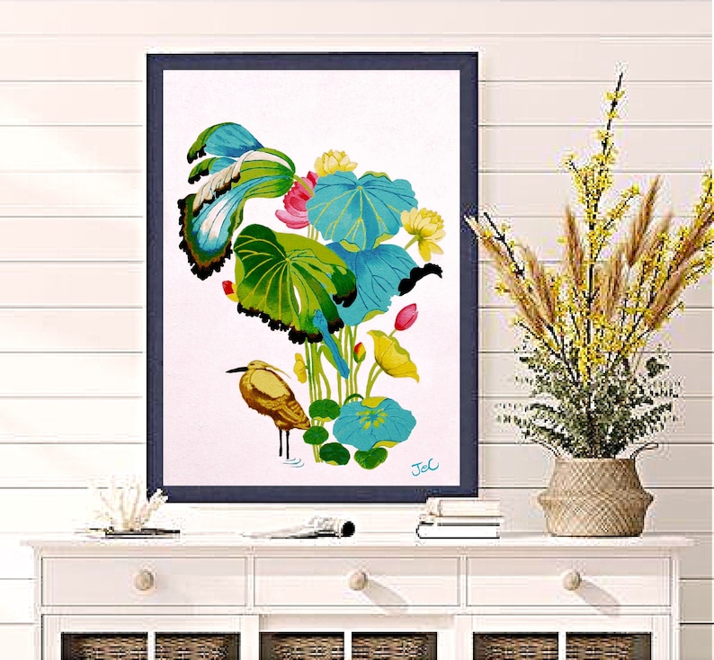 Print of my original water lilies painting featuring a nature scene with a heron wading bird and vibrant lotus plants against a white background. A long-beaked, golden-brown bird stands in ripples of water at the bottom left. Large, oversized lily pads in shades of bright green, teal, and turquoise dominate the center, detailed with delicate blue veins and scalloped dark edges. Soft pink and pale yellow lotus blossoms bloom on tall, slender stems. Signed "JeC" in script at the bottom right.