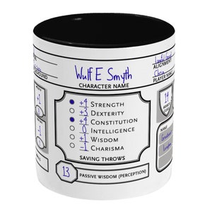May include: White ceramic mug with a black rim. The mug features a Dungeons and Dragons character sheet with the name "Wulf E Smyth" and stats for Strength, Dexterity, Constitution, Intelligence, Wisdom, and Charisma. The mug also includes a section for saving throws and passive wisdom (perception).