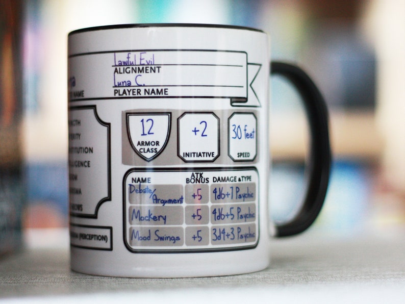 May include: White ceramic mug with a black handle. The mug has a character sheet design with the text "Lawful Evil", "Alignment", "Luna C.", "Player Name", "12 Armor Class", "+2 Initiative", "30 feet Speed", "Debate/Argument +5 9d6+7 Psychic", "Mockery +5 4d6+5 Psychic", and "Mood Swings +5 3d4+3 Psychic".