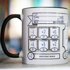 May include: White ceramic mug with a black handle. The mug has a printed Dungeons and Dragons character sheet with the following information: ENTP, Class: Human, Level: 3, Background: FXS. The character sheet also includes stats for Strength, Constitution, Wisdom, Dexterity, Intelligence, and Charisma.