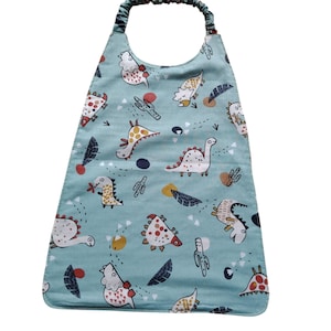 Puede incluir: Babero azul claro para bebé con un estampado repetido de dinosaurios de dibujos animados, cactus y otras formas coloridas. El babero tiene la parte inferior redondeada y un lazo de tela para el cuello.