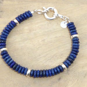 May include: A blue lapis lazuli beaded bracelet with silver accents and a silver clasp.