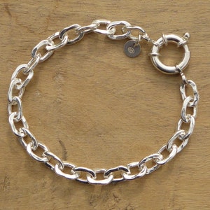 Puede incluir: Un brazalete de cadena de plata con un acabado texturizado y un cierre de langosta.