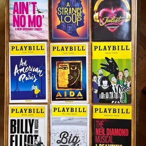 May include: Nine Playbill theater programs with yellow borders. Titles include "Ain't No Mo'," "A Strange Loop," "Juliet," "An American in Paris," "Aida," "Beetlejuice," "Billy Elliot," "Big Fish," and "A Beautiful Noise."