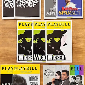 May include: A selection of Playbill theatre programmes, showcasing shows like "Fiddler on the Roof," "Monty Python's Spamalot," and "Wicked." The programmes feature vibrant covers with show titles and theatre names. The collection includes "Torch Song" and "The Sign in Sidney Brustein's Window."