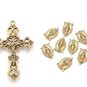 May include: Gold-toned metal cross charm with a detailed design and a figure of Jesus Christ. The charm is surrounded by ten gold-toned metal oval charms with a figure of the Virgin Mary.