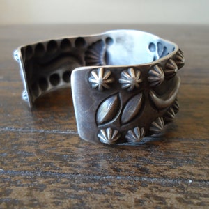 K&ouml;nnte beinhalten: Ein silbernes Armband mit aufwendigen Designs, darunter ein Halbmond, Sterne und Bl&auml;tter. Das Armband ist aus massivem Silber gefertigt und hat eine polierte Oberfl&auml;che.