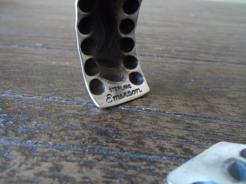 K&ouml;nnte beinhalten: Nahaufnahme eines silbernen Armbands mit einer strukturierten Oberfl&auml;che und einer gepr&auml;gten Inschrift mit der Aufschrift "STERLING E.MARSON".