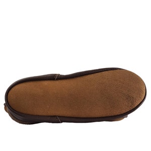 May include: The underside of a brown leather slipper with a suede insole.