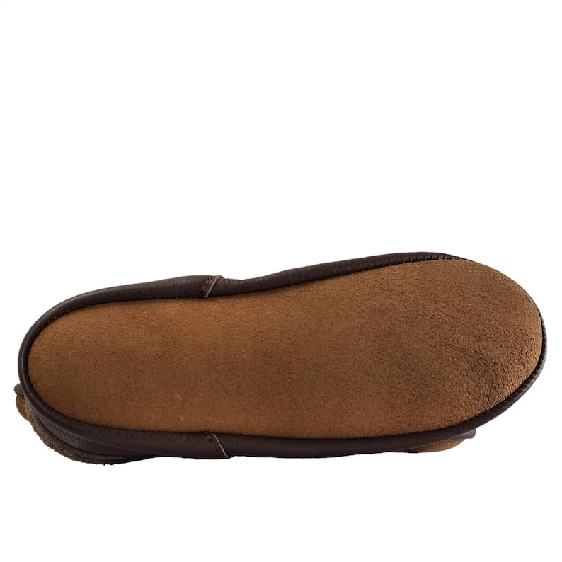 May include: The underside of a brown leather slipper with a suede insole.