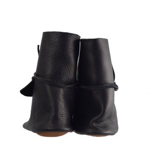 K&ouml;nnte beinhalten: Ein Paar schwarze Lederstiefel mit Schn&uuml;rsenkeln. Die Stiefel haben eine abgerundete Spitze und einen niedrigen Absatz.