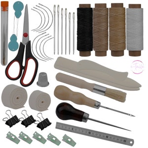 May include: Leather craft kit containing tools, needles, thread, and a ruler. The kit features a leather awl, a stitching pony, a brush, and a thimble. The kit also includes a selection of needles, thread, and a ruler.