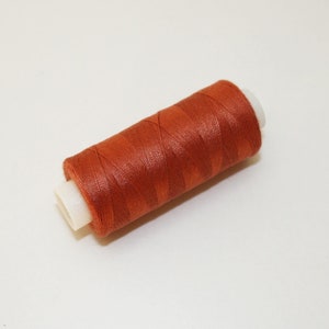 Op de afbeelding: Een spoel oranje draad.