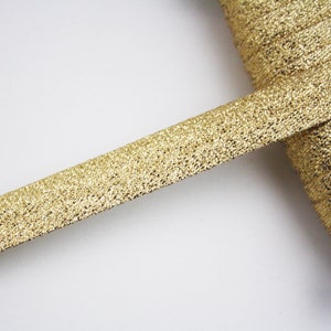 Peut inclure: Un rouleau de galon métallique doré à surface texturée.