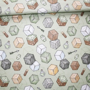 Op de afbeelding: Een groene stof met een herhalend patroon van verschillende vormen en kleuren. Het patroon bevat kubussen, drankjes, pijlen en andere geometrische vormen. De stof is perfect voor knutselprojecten, quilten en andere creatieve bezigheden.