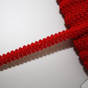 May include: Red decorative trim with a scalloped design. The trim is made of a soft, flexible material and is perfect for adding a touch of elegance to any project.