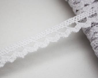 May include: White crochet lace trim with a delicate heart pattern. The lace is approximately 1/2 inch wide.