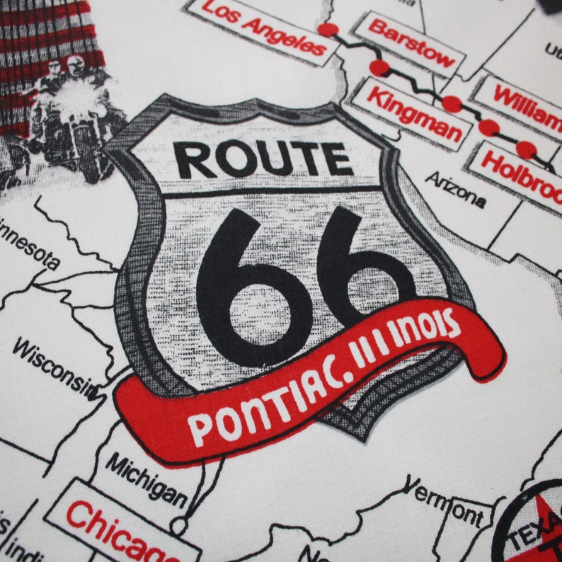 May include: A white map featuring a black and white Route 66 sign with a red banner reading "PONTIAC. III INOIS". The map depicts the route of Route 66 across the United States, with cities highlighted in red.