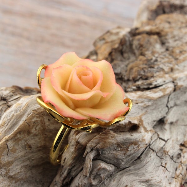 Bague en métal doré, réglable, agrémentée d'une rose,  modelée à la main en  porcelaine froide,