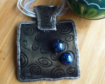 Collier pendentif  email gris fond spirales avec gouttes en verre dichroïque bleues