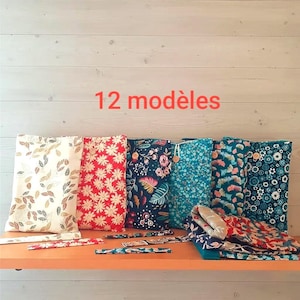Peut inclure: Plusieurs pochettes en tissu avec divers motifs floraux et botaniques, dont des marguerites rouges, des motifs floraux bleus et des feuilles vertes. Le texte "12 modèles" est visible en rouge. Les pochettes sont présentées sur une étagère orange.