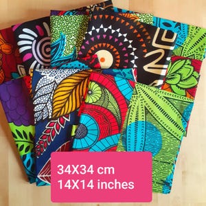 Op de afbeelding: Een verzameling kleurrijke stoffen vierkanten met diverse patronen. De stoffen tonen levendige kleuren en geometrische en bloemmotieven. Elk vierkant meet 34x34 cm.