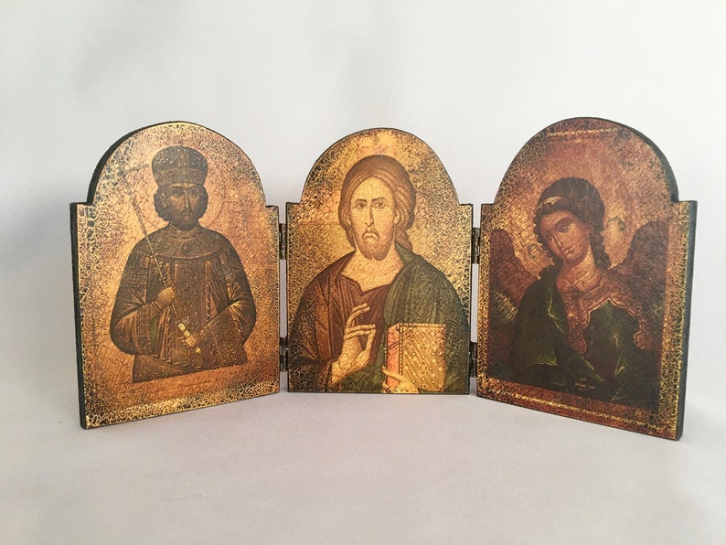 May include: A wooden triptych with three panels, each featuring a religious icon. The left panel depicts a man with a crown and a staff, the middle panel shows a man with a book, and the right panel shows a person with wings.